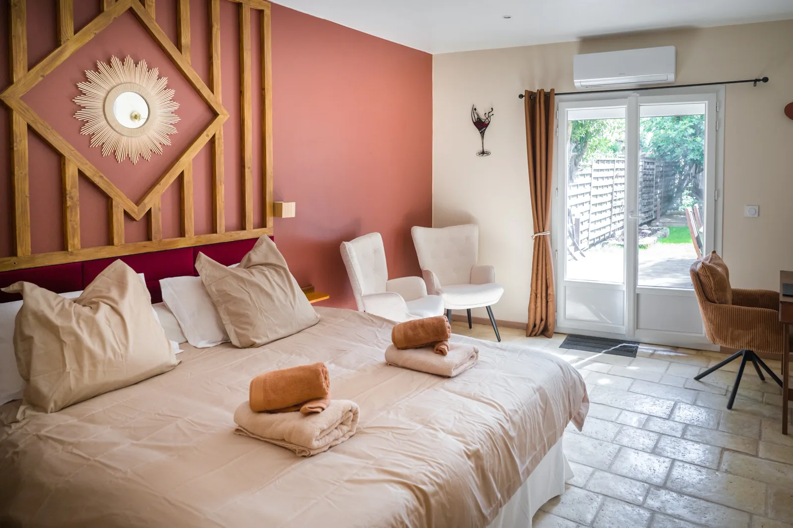 Chambre principale avec tomettes octogonales d'origine, mur terracotta et porte-fenêtre vers le jardin
