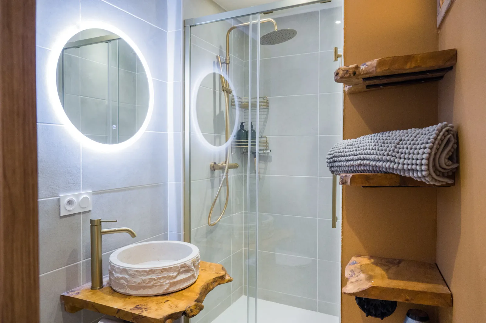 Salle d'eau de l'appartement avec mur terracotta et vasque pierre
